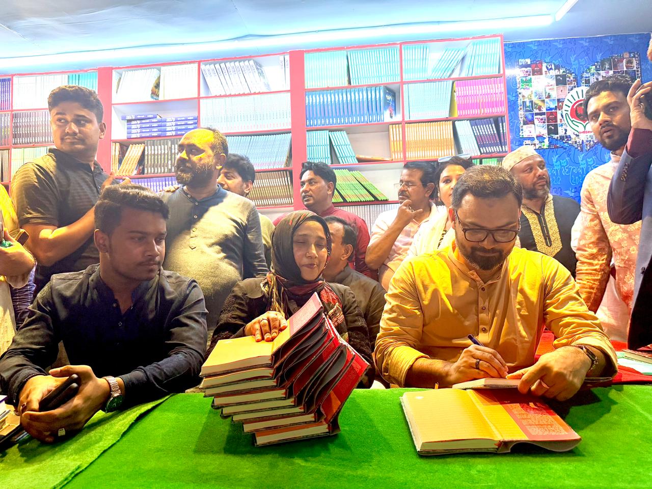 চলন্তিকায় নিজ বইয়ে অটোগ্রাফ দিচ্ছেন আমিনুল